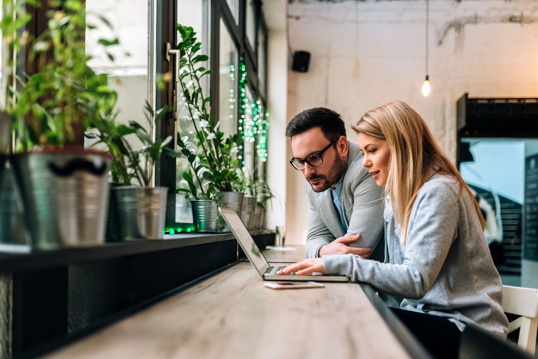 Man and woman sitting and looking at a laptop